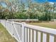 Backyard view featuring a pristine white vinyl fence and lush green space at 15579 Stone House Dr, Brooksville, FL 34604