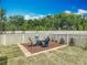 Backyard with fire pit area and seating; white vinyl fence surrounds property at 15579 Stone House Dr, Brooksville, FL 34604