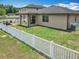 Backyard with white picket fence, patio, and well-maintained lawn at 15579 Stone House Dr, Brooksville, FL 34604