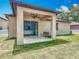 Exterior view of backyard featuring covered porch and grassy area at 15579 Stone House Dr, Brooksville, FL 34604