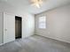 Bright bedroom with neutral walls, carpeted floor, ceiling fan, and closet with an open, sliding door at 15579 Stone House Dr, Brooksville, FL 34604
