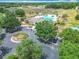 Aerial view of the community pool featuring palm trees, seating, and clubhouse at 15579 Stone House Dr, Brooksville, FL 34604