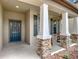 Welcoming front porch with stone pillars, rocking chairs, and a beautifully decorated blue front door at 15579 Stone House Dr, Brooksville, FL 34604