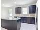 Open kitchen with dark cabinets, granite countertops, an island, stainless steel appliances, and tile flooring at 15579 Stone House Dr, Brooksville, FL 34604