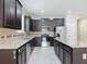 Kitchen with granite countertops, stainless steel appliances, dark cabinets, tile flooring and an island at 15579 Stone House Dr, Brooksville, FL 34604