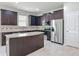 Modern kitchen with granite countertops, stainless steel appliances, and dark cabinetry at 15579 Stone House Dr, Brooksville, FL 34604