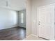 Bright entryway featuring hardwood floors, neutral paint, and a clear view into a living space at 15579 Stone House Dr, Brooksville, FL 34604