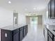 Open floor plan from the kitchen into the living area with a tray ceiling and sliding glass doors to the lanai at 15579 Stone House Dr, Brooksville, FL 34604