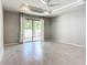 Bright living room with neutral walls, tile flooring, and sliding glass doors to the backyard patio at 15579 Stone House Dr, Brooksville, FL 34604