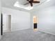 Spacious main bedroom featuring a tray ceiling, fan, walk-in closet, and ensuite bathroom at 15579 Stone House Dr, Brooksville, FL 34604
