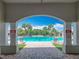 View of the community pool area through covered entrance with lounge chairs and palm trees at 15579 Stone House Dr, Brooksville, FL 34604