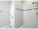 Tiled shower featuring tiled walls with decorative border and tiled floor at 15579 Stone House Dr, Brooksville, FL 34604