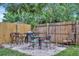 A backyard features a stone paver patio with dining set and a wooden fence at 15591 Darien Way, Clearwater, FL 33764