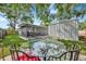 Inviting backyard with a glass table, screened-in patio, and shed at 15591 Darien Way, Clearwater, FL 33764