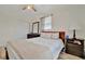 Comfortable bedroom featuring a ceiling fan, closet, and bedside table with a lamp at 15591 Darien Way, Clearwater, FL 33764