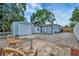 Outdoor patio area with detached garage and mature trees, perfect for relaxation and outdoor activities at 15591 Darien Way, Clearwater, FL 33764