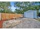 Outdoor patio area with detached garage and mature trees, perfect for relaxation and outdoor activities at 15591 Darien Way, Clearwater, FL 33764