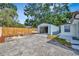 Backyard featuring a detached garage and outdoor seating area, perfect for storage and relaxation at 15591 Darien Way, Clearwater, FL 33764
