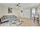 Inviting living room with ceiling fan, light hardwood floors, comfortable seating, and glass coffee table at 15591 Darien Way, Clearwater, FL 33764