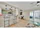 Open-concept living area features bar seating, dining space, and laminate floors at 15591 Darien Way, Clearwater, FL 33764