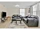 Comfortable living room with hardwood floors, large window and black leather seating at 15591 Darien Way, Clearwater, FL 33764