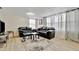 Cozy living room with hardwood floors, large window and comfortable black leather seating at 15591 Darien Way, Clearwater, FL 33764