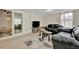 Spacious living room with hardwood floors, large glass sliding door and comfortable black leather seating at 15591 Darien Way, Clearwater, FL 33764