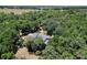 Aerial view of home nestled within a lush landscape of green trees and a nearby lake at 16224 Iola Woods Trl, Dade City, FL 33523