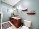 Bathroom with stained cabinets, neutral countertop, and light green paint at 16224 Iola Woods Trl, Dade City, FL 33523