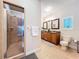 Bright bathroom featuring a walk-in shower, toilet, and dual sink vanity at 16224 Iola Woods Trl, Dade City, FL 33523