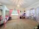 Colorful bedroom with carpet, light fixture, and large window at 16224 Iola Woods Trl, Dade City, FL 33523