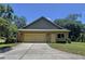 Charming home exterior featuring a two-car garage, well-maintained lawn, and inviting front entrance at 16224 Iola Woods Trl, Dade City, FL 33523