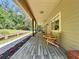 Inviting front porch with wooden flooring and comfortable rocking chairs to sit and relax outside at 16224 Iola Woods Trl, Dade City, FL 33523