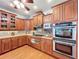 Well-equipped kitchen features stainless steel appliances, stylish backsplash, and ample wood cabinetry at 16224 Iola Woods Trl, Dade City, FL 33523