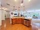 Bright kitchen area with stainless steel dishwasher, wooden cabinets, and island with pendant lights at 16224 Iola Woods Trl, Dade City, FL 33523