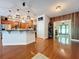 Charming kitchen island with pendant lighting and wood floors is adjacent to an open entrance at 16224 Iola Woods Trl, Dade City, FL 33523