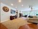 Open-concept living room with a fireplace, a TV, hardwood floors and neutral-toned walls at 16224 Iola Woods Trl, Dade City, FL 33523