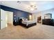 Relaxing main bedroom with a decorative blue accent wall, king bed, and ample closet space at 16224 Iola Woods Trl, Dade City, FL 33523