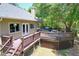 Large wooden deck off the home's rear features a hot tub and outdoor seating area at 16224 Iola Woods Trl, Dade City, FL 33523