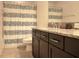 Well-lit bathroom featuring a vanity with granite countertop and tub with patterned shower curtain at 19314 Long Lake Ranch Blvd, Lutz, FL 33558