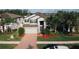 Aerial view of a charming home, showcasing its well-manicured lawn, brick-accented facade, and a spacious driveway at 19314 Long Lake Ranch Blvd, Lutz, FL 33558