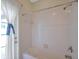 The bright bathroom includes a shower and tub, with a curtain and natural light streaming in at 2218 Valterra Vista Way, Valrico, FL 33594