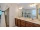 Dual sink bathroom with wood cabinets, sheer curtains, and a spacious feel at 2218 Valterra Vista Way, Valrico, FL 33594