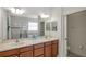 Spacious bathroom featuring dual sinks, wood cabinets, large mirrors, and a separate shower at 2218 Valterra Vista Way, Valrico, FL 33594