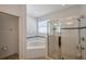 Bright bathroom featuring a corner tub, glass-enclosed shower, and neutral tile at 2218 Valterra Vista Way, Valrico, FL 33594