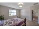 Cozy bedroom featuring a decorative light fixture, neutral walls, and a window for natural light at 2218 Valterra Vista Way, Valrico, FL 33594