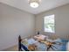 Cozy bedroom featuring a window offering natural light and a decorative ceiling light fixture at 2218 Valterra Vista Way, Valrico, FL 33594