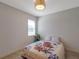 Bright bedroom with a decorative light fixture, neutral walls, and window for natural light at 2218 Valterra Vista Way, Valrico, FL 33594