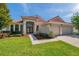 Attractive single-story home boasting a red tile roof, well-maintained lawn, and an inviting double-door entryway at 2218 Valterra Vista Way, Valrico, FL 33594
