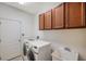 Laundry room with washer, dryer, wash sink, and upper cabinets at 2218 Valterra Vista Way, Valrico, FL 33594